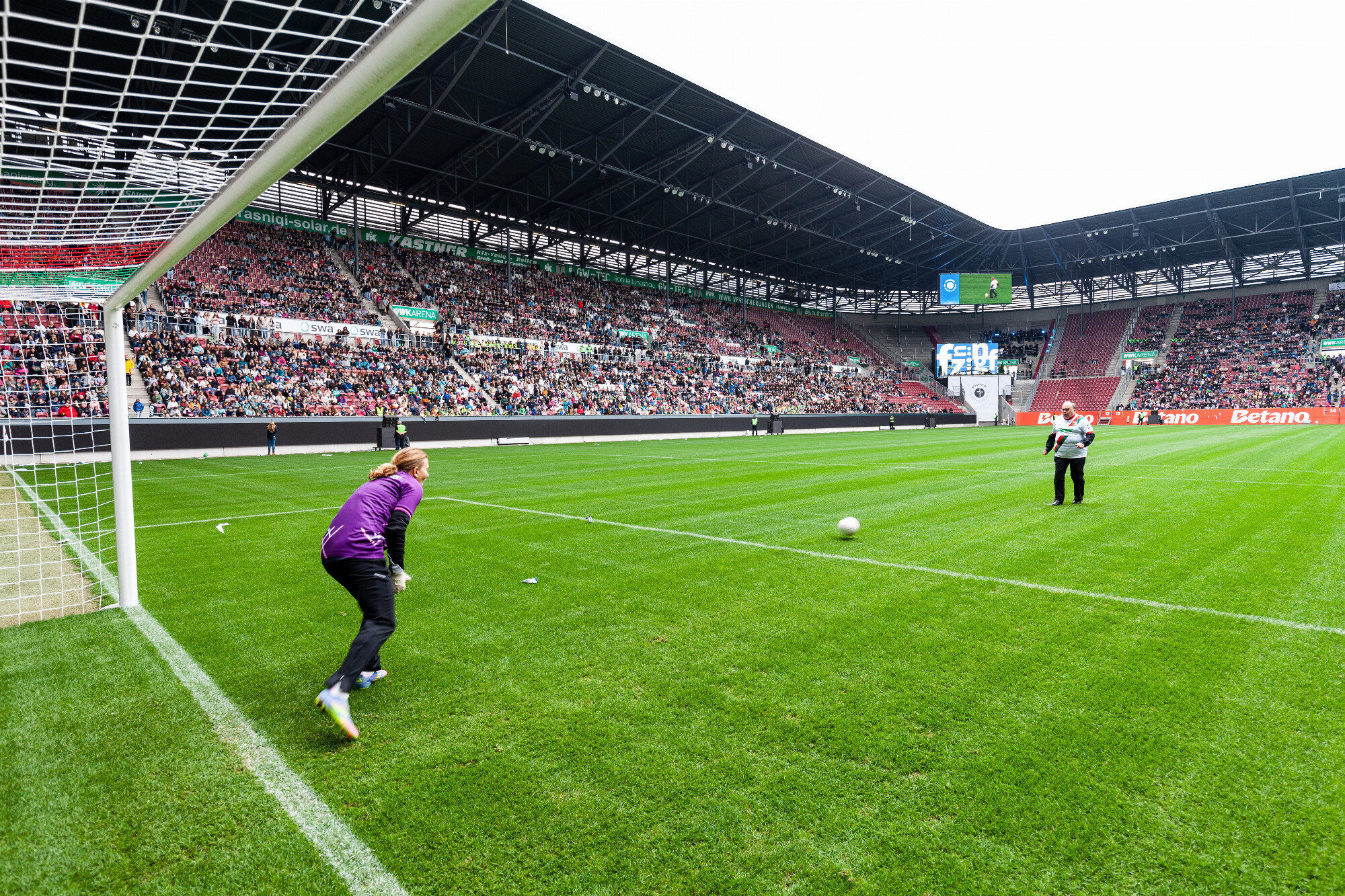 Bischof Bertram Meier schießt den Elfmeter übers Rasengrün, WWK Arena Augsburg / Schulwerk